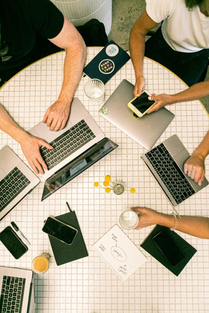 pexels-photo-3194519-3194519 Top view of a team collaborating with laptops, phones, and notes in a modern office.
